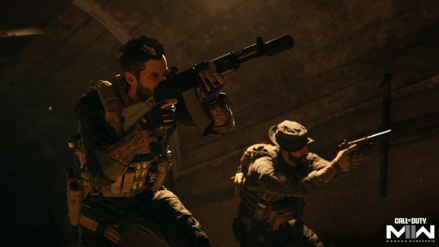 Soap (left) and Price (right), two main characters in the Call of Duty: Modern Warfare franchise, wearing tactical military equipment and moving underground in a tunnel holding weapons.