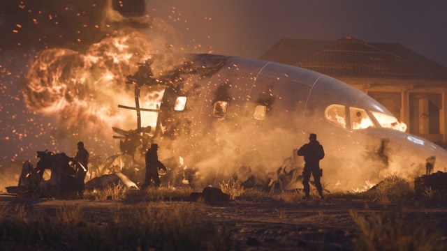 A group of soldiers standing around a plane crash in MW3.