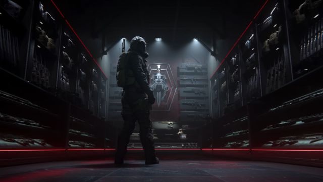 Image from the MW3 multiplayer trailer which shows a character in a dimly lit weapon room. There is a red banner in the wall in the background.